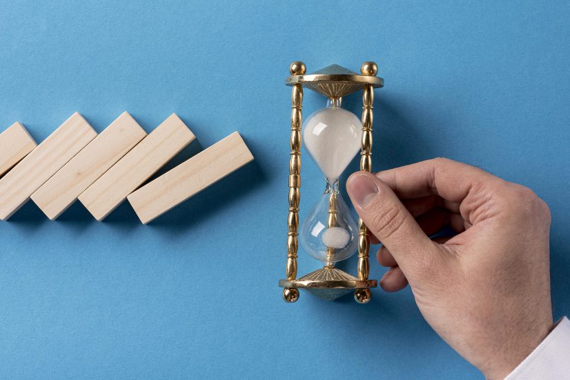top-view-domino-pieces-with-businessman-holding-hourglass